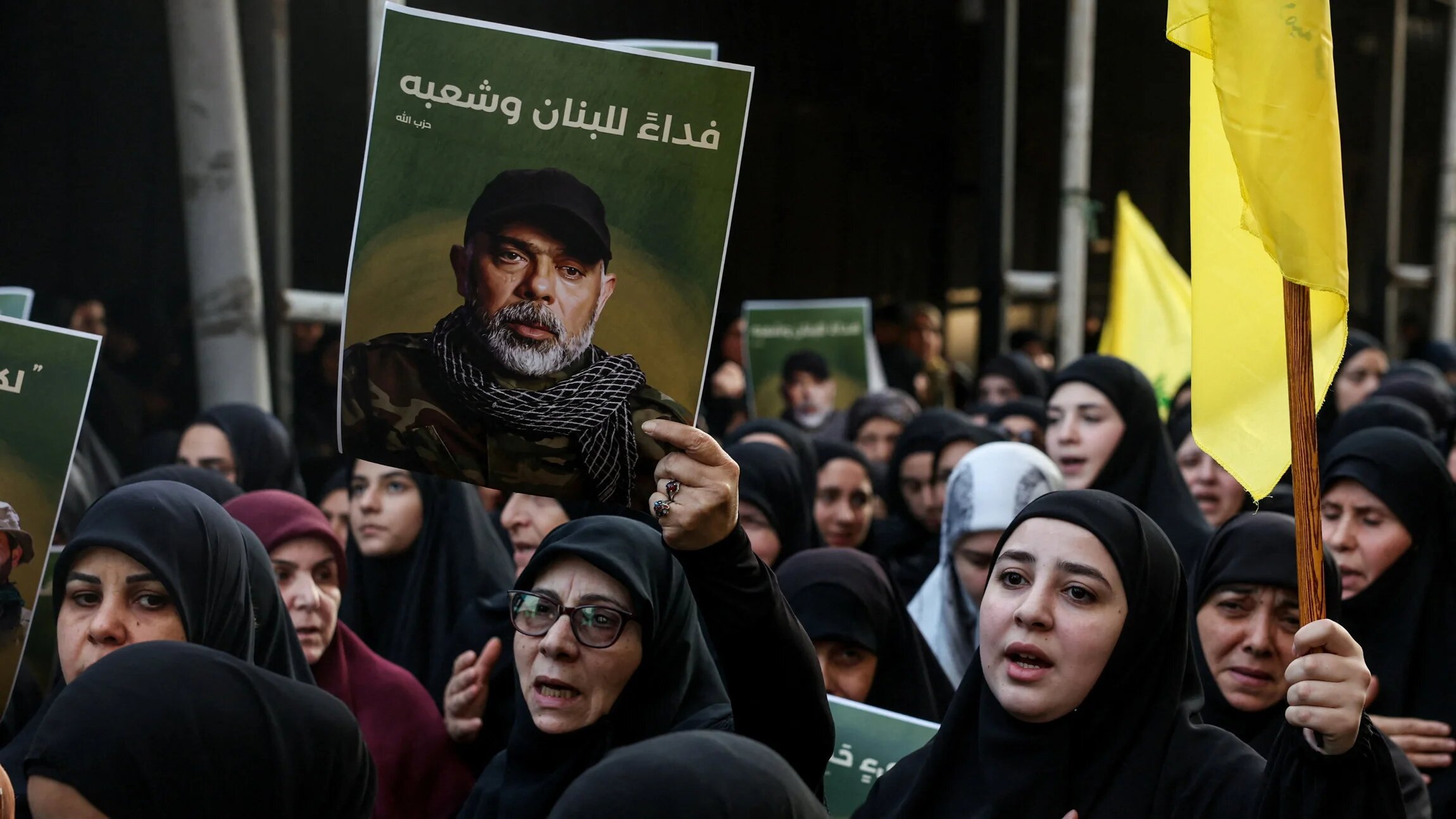 A woman holds a picture of Hezbollah's top military official, Haytham Ali Tabtabai, during the funeral for him and other people who were killed by an Israeli air strike on Sunday, in Beirut, 24 November 2025 (Reuters/Mohamed Azakir)