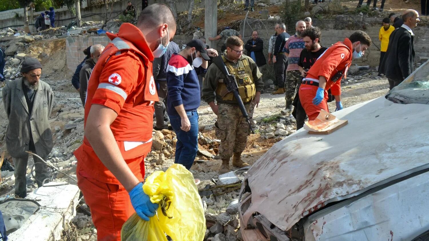 First responders search around a damaged car at the site of an overnight Israeli strike on Ain Yaacoub in Akkar, Lebanon on 12 November 2024.