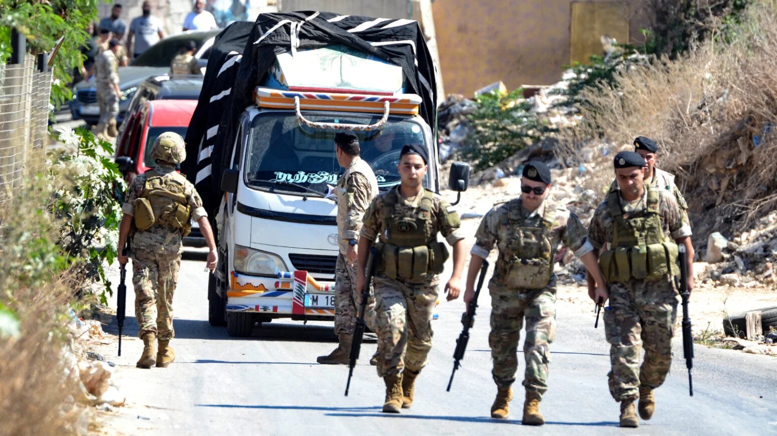 Lebanese army soldiers stand guard as a truck loaded with weapons leaves the Palestinian refugee camp of Beddawi, near the northern city of Tripoli on 13 September 2025 (AFP)