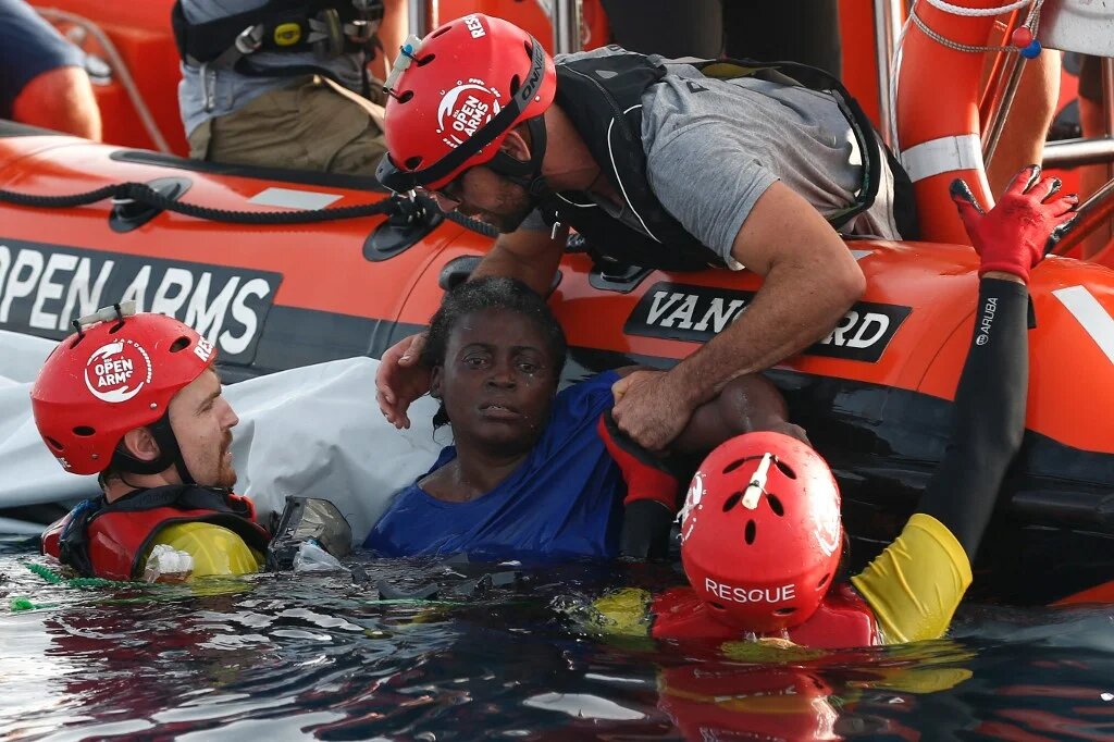 Des secouristes de l’ONG Proactiva Open Arms sauvent une migrante camerounaise, Josepha, 40 ans, au large des côtes libyennes le 17 juillet 2018 (AFP/Pau Barrena) 