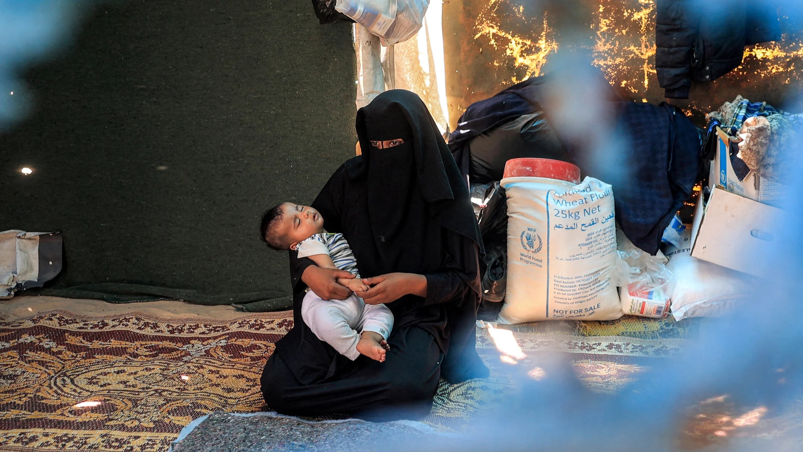 KhanYounis_Gaza_WomanHoldChild_11JUL2024_AFP_EyadBaba
