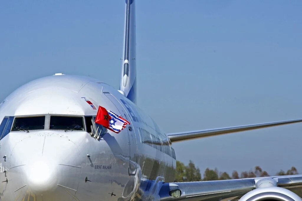 Les drapeaux du Maroc, d’Israël et des États-Unis sur un avion El Al après l’atterrissage à Rabat, du premier vol commercial direct Israël-Maroc, le 22 décembre 2020 (AFP)
