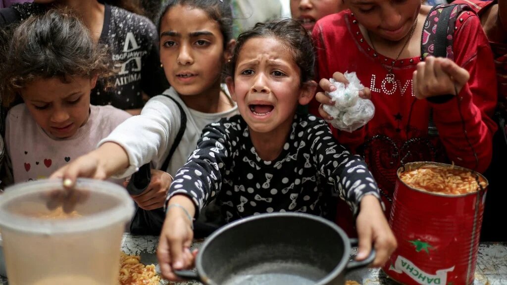 Palestinians gather to receive a hot meal at a food distribution centre in Gaza’s Nuseirat camp on 30 April 2025 (Eyad Baba/AFP)