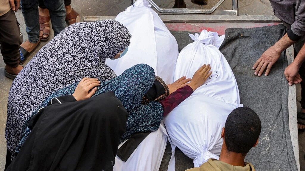 People mourn victims of Israel’s bombardment in Gaza City on 18 March 2025 (Omar al-Qattaa/AFP)