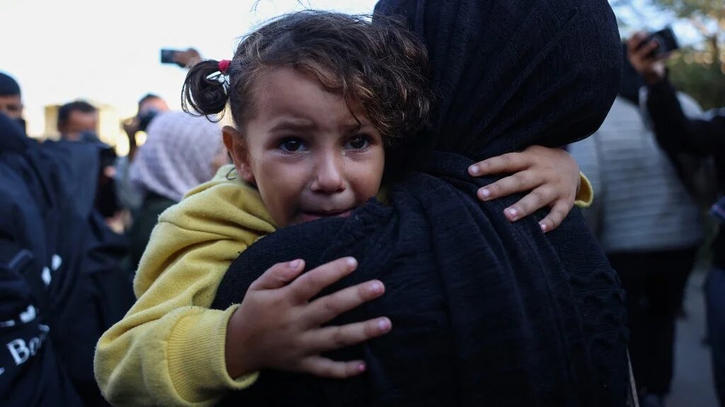 A girl cries as she’s carried by a Palestinian woman mourning relatives killed in Israeli strikes in al-Mawasi, Gaza, on 12 November 2024 (Bashar Taleb/AFP)