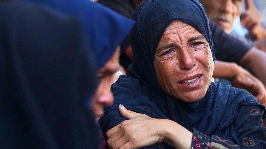 Palestinians mourn a relative killed in Israeli strikes in Khan Younis, Gaza, on 22 July 2025 (AFP)