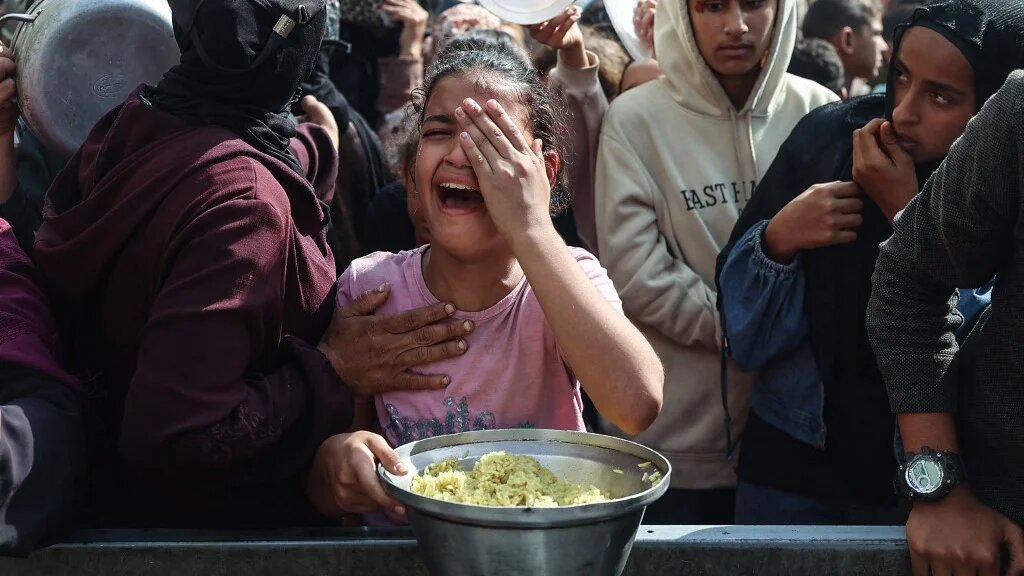 A displaced Palestinian girl receives food in Nuseirat, Gaza, on 2 November 2025 (Eyad Baba/AFP)