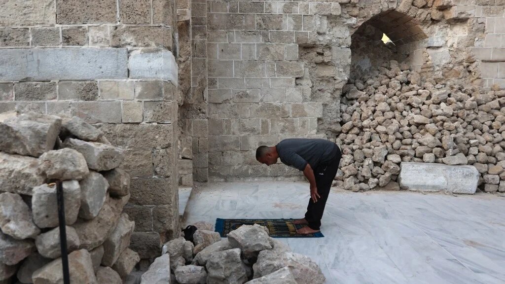 A Palestinian man performs Eid al-Fitr prayers at Gaza City’s historic Omari Mosque on 30 March 2025 (Omar al-Qattaa/AFP)