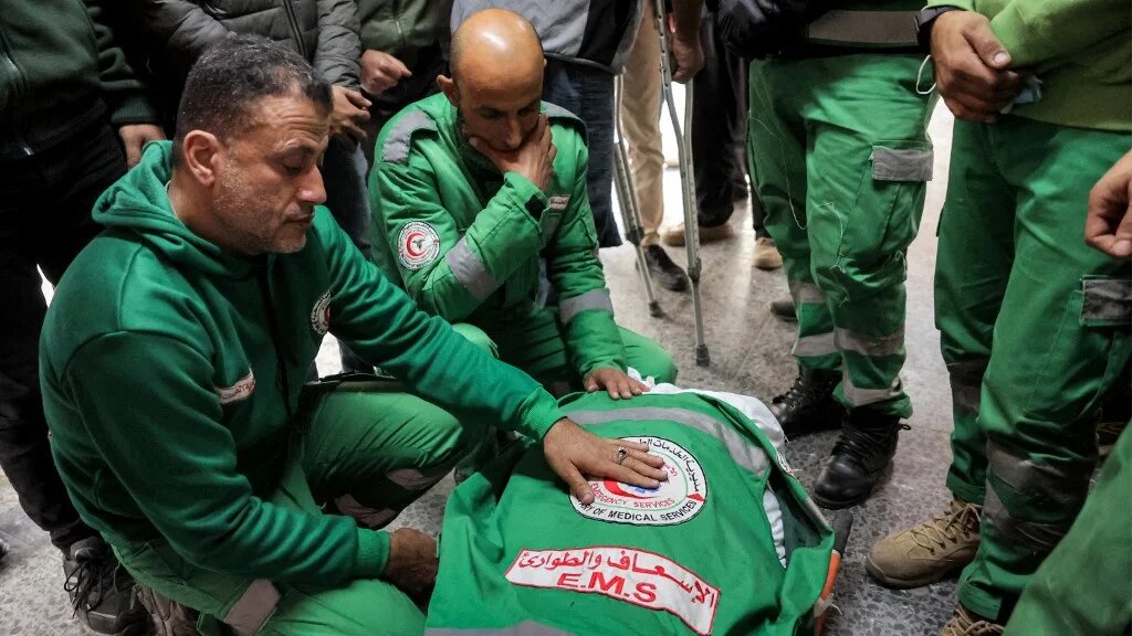 Palestinian Red Crescent paramedics mourn a colleague after an Israeli air strike in northern Gaza on 4 January 2025 (Omar al-Qattaa/AFP)