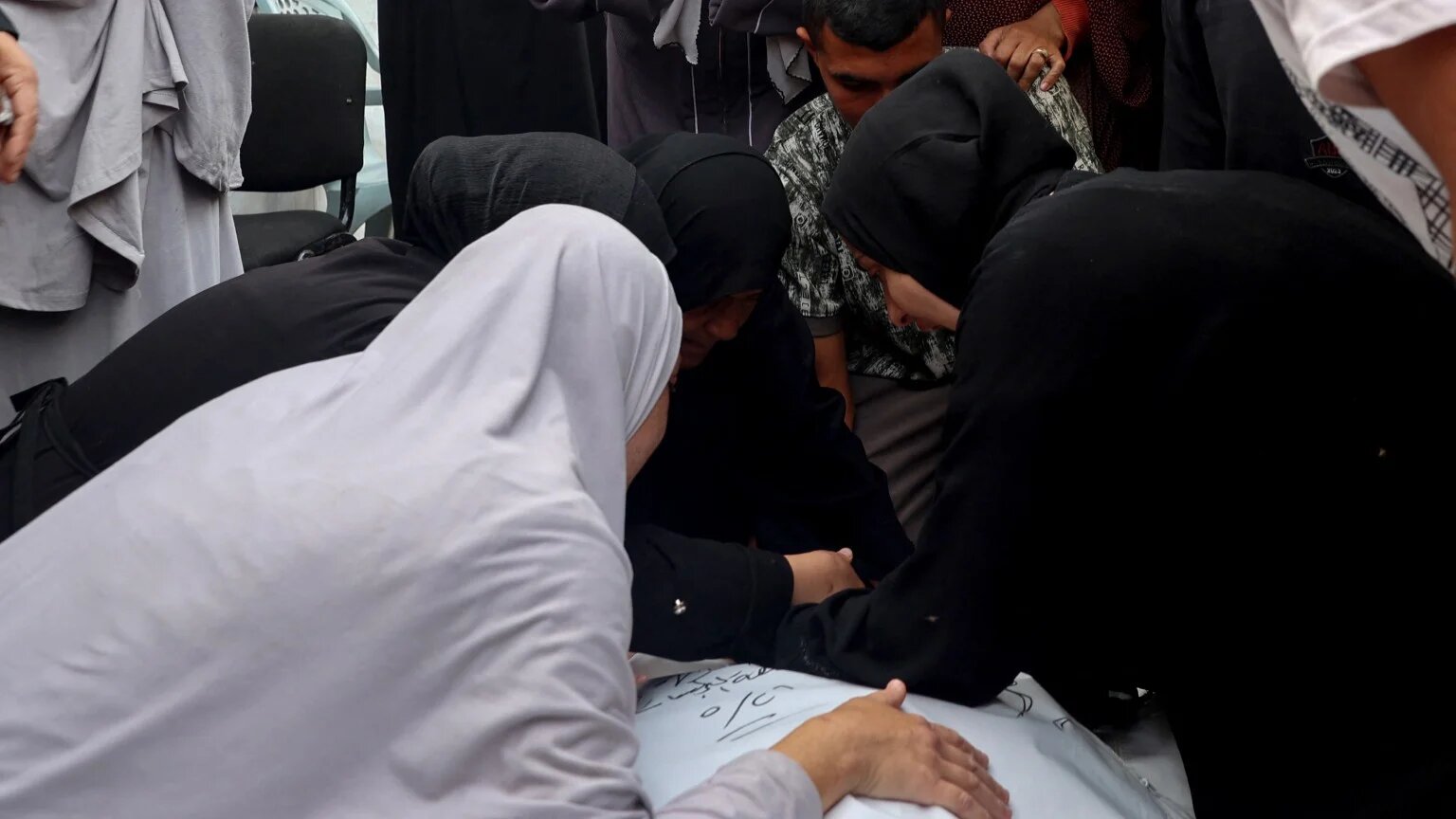 Palestinians mourn their relatives killed by an Israeli strike on a camp for internally displaced people in the Tel al-Sultan neighbourhood in western Rafah on 17 May, 2024 (Eyad Baba/AFP)