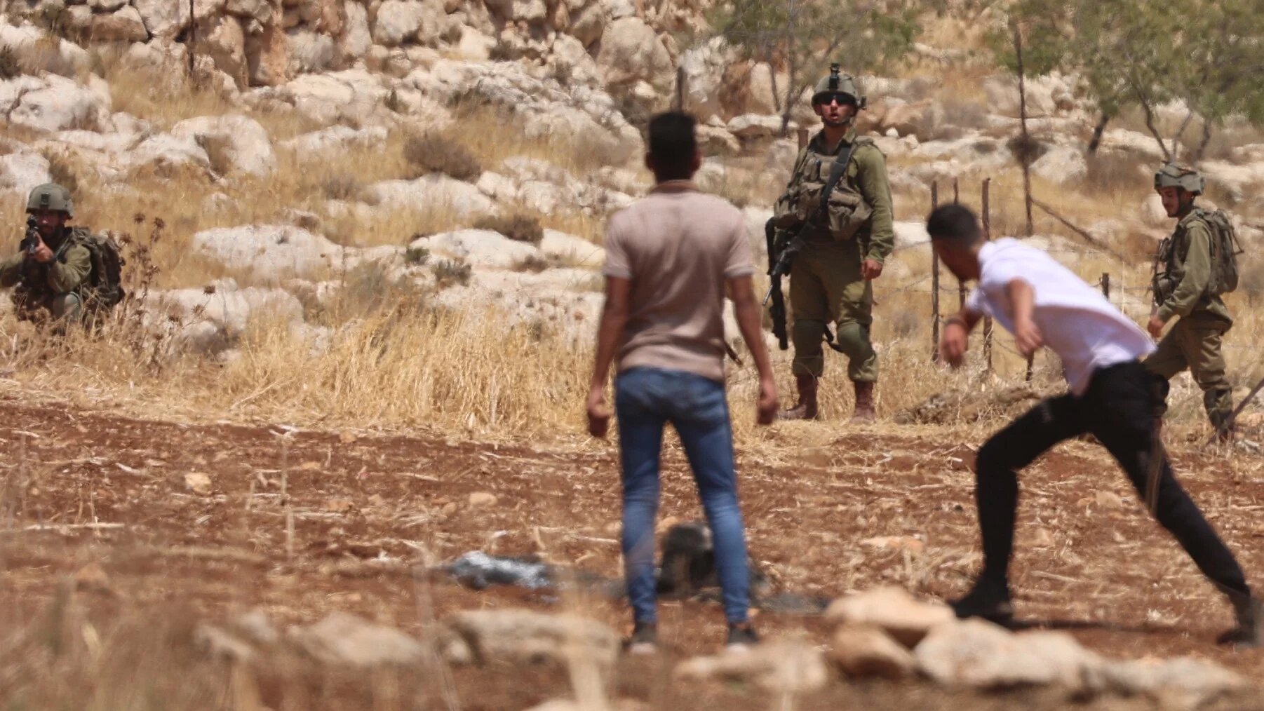 Young Palestinians confront Israeli security forces during a demonstration against the establishment of Israeli outposts, in Beit Dajan, east of the occupied West Bank city of Nablus on 5 August, 2022 (AFP)
