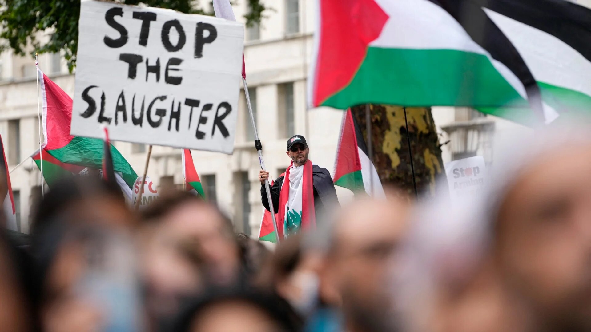 Pro-Palestinian supporters hold placards and wave flags on Downing Street in central London on 19 July 2025 (Carlos Jasso/AFP)