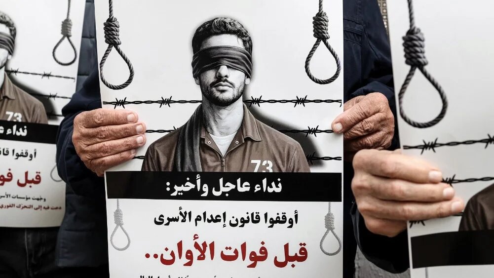 Protesters hold placards reading “Urgent and final appeal: Stop the execution of prisoners law before it’s too late” in Ramallah, in the occupied West Bank, on 31 March 2026 (Zain Jaafar/AFP)