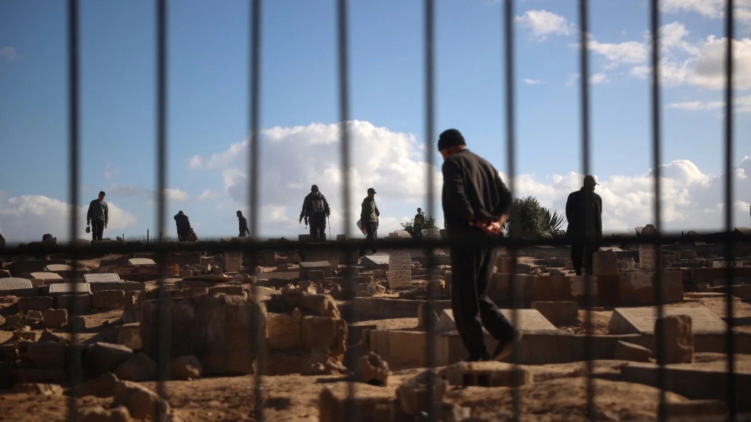 Palestinians inspect the damage at a cemetery after an Israeli airstrike on the Nuseirat refugee in the central Gaza Strip on 13 December 2024.