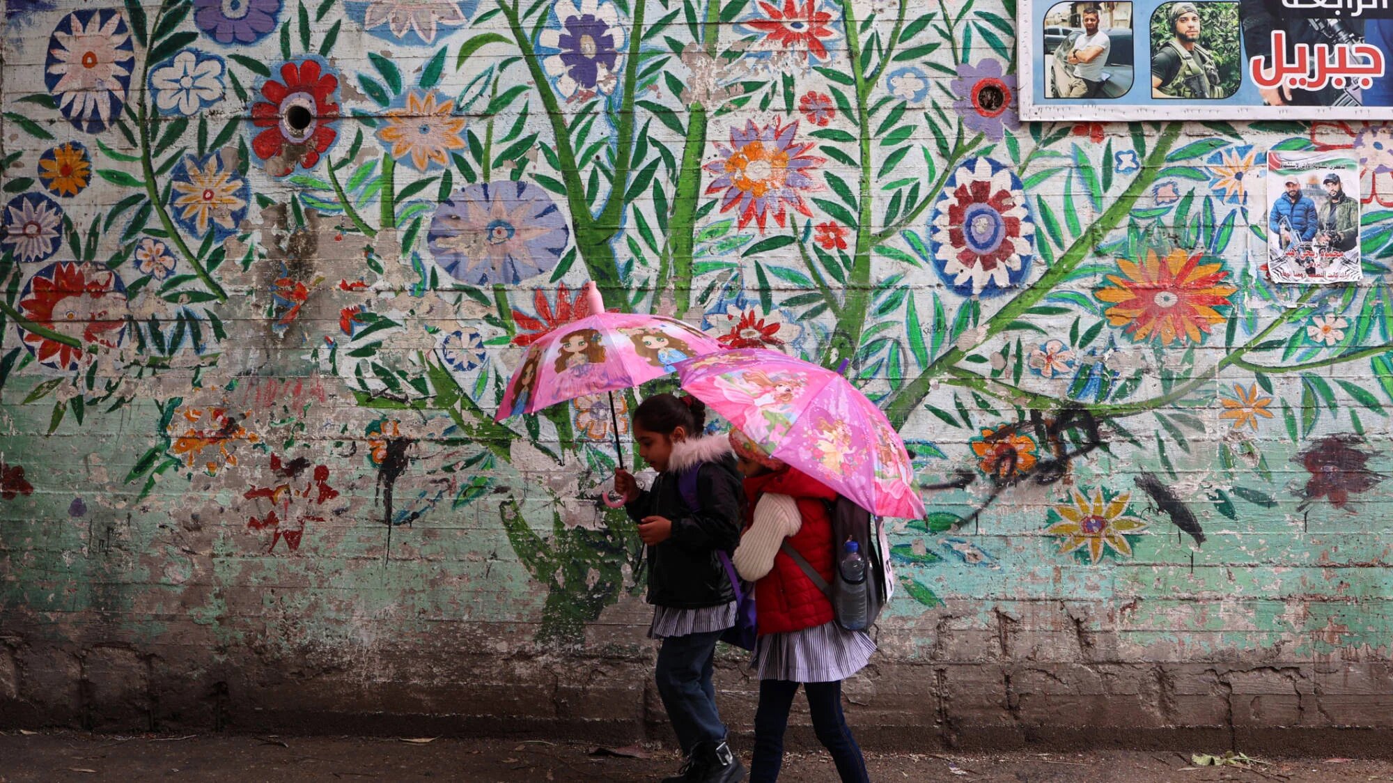 Palestinian school children walk past a mural at a United Nations school in Balata camp east of Nablus in the occupied West Bank, on 6 February 2025 (AFP)