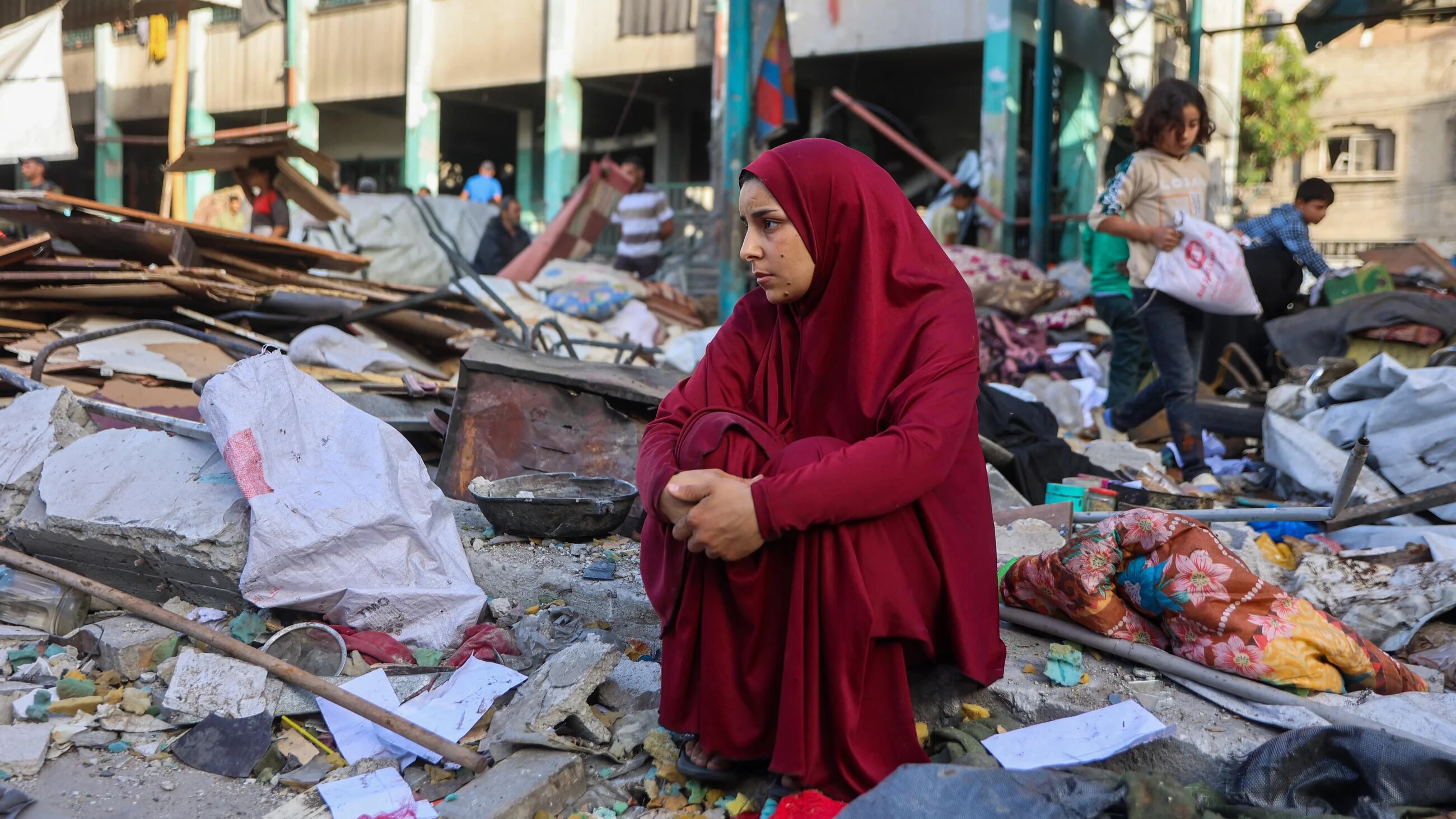 A woman sits amid the rubble at the Fahmi Al-Jarjawi school in Gaza City, on 26 May, 2025, following an Israeli strike (AFP/Omar al-Qattaa)