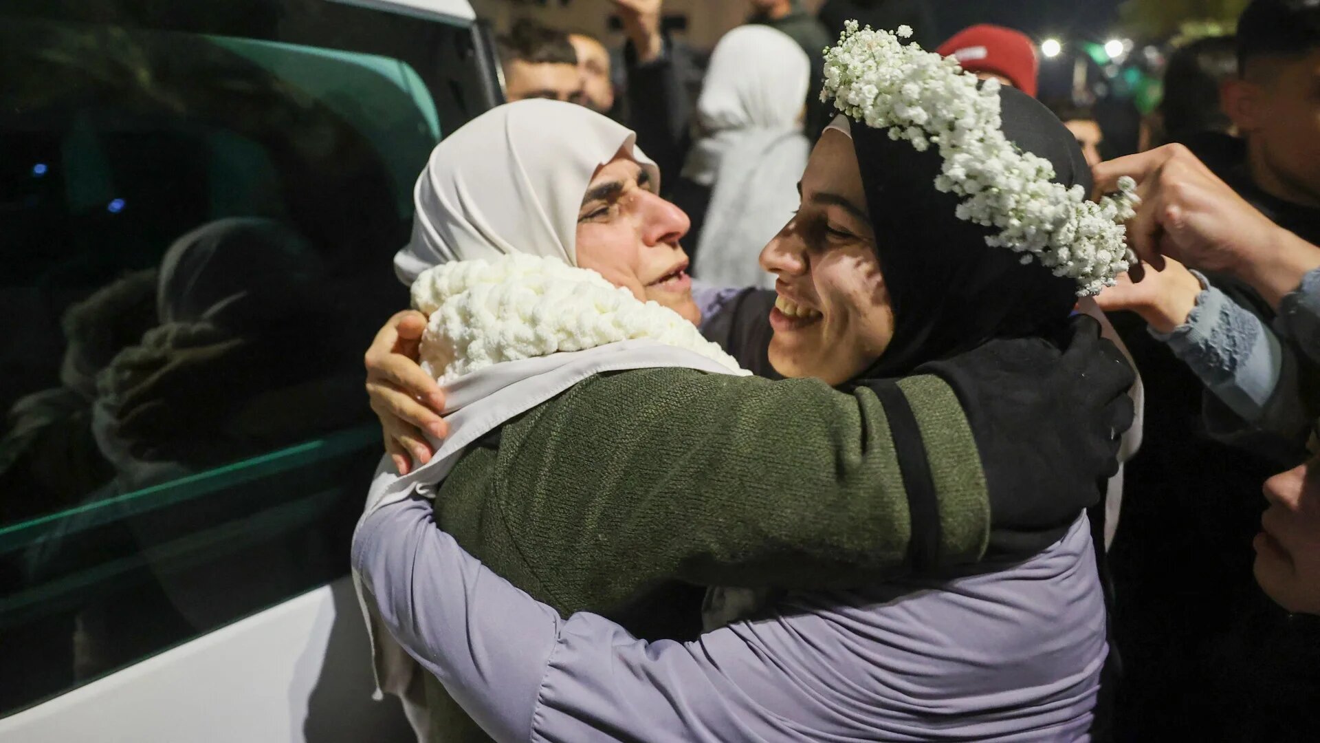 Palestinian prisoner Baraah Fuqaha (right), is welcomed by relatives upon the arrival of some 90 prisoners set free by Israel in the early hours of 20 January 2025 in the occupied West Bank town of Beitunia (AFP/Zain Jaafar)