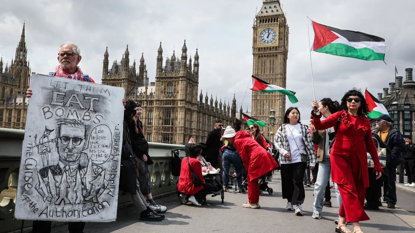 A protester displays a satirical sign targeting UK Prime Minister Keir Starmer during a demonstration in support of Gaza in London, 4 June 2025 (Adrian Dennis/AFP)