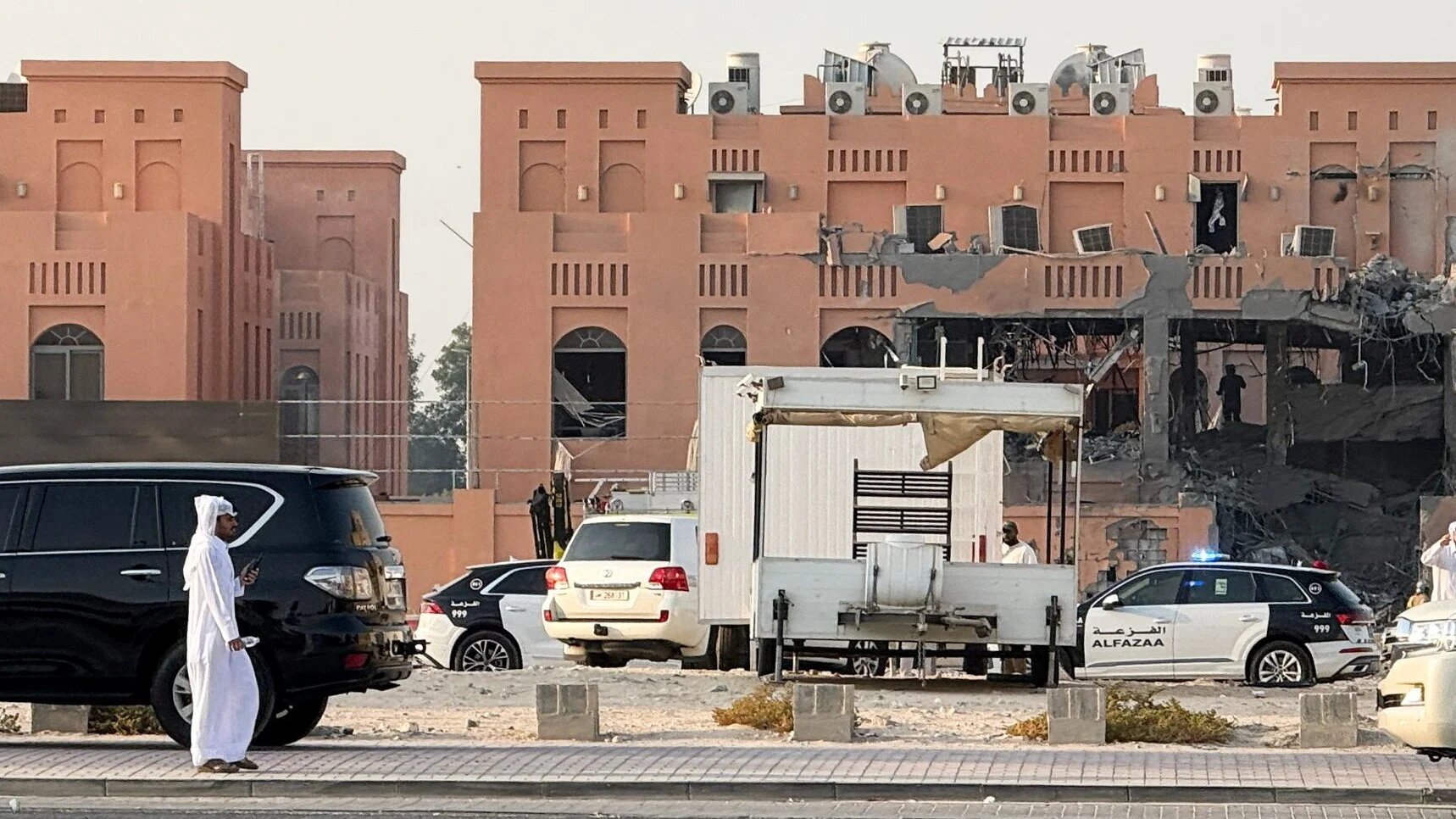 A man walks near a damaged residential building in the Qatari capital Doha that was targeted by Israel on 9 September 2025 (Ibraheem Abu Mustafa/Reuters)