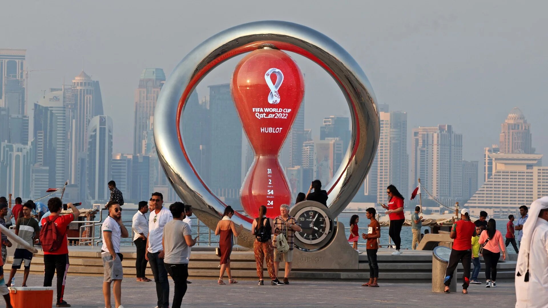 People walking past the Qatar 2022 FIFA World Cup countdown clock in the Qatari capital Doha on 20 October 2022 (AFP)