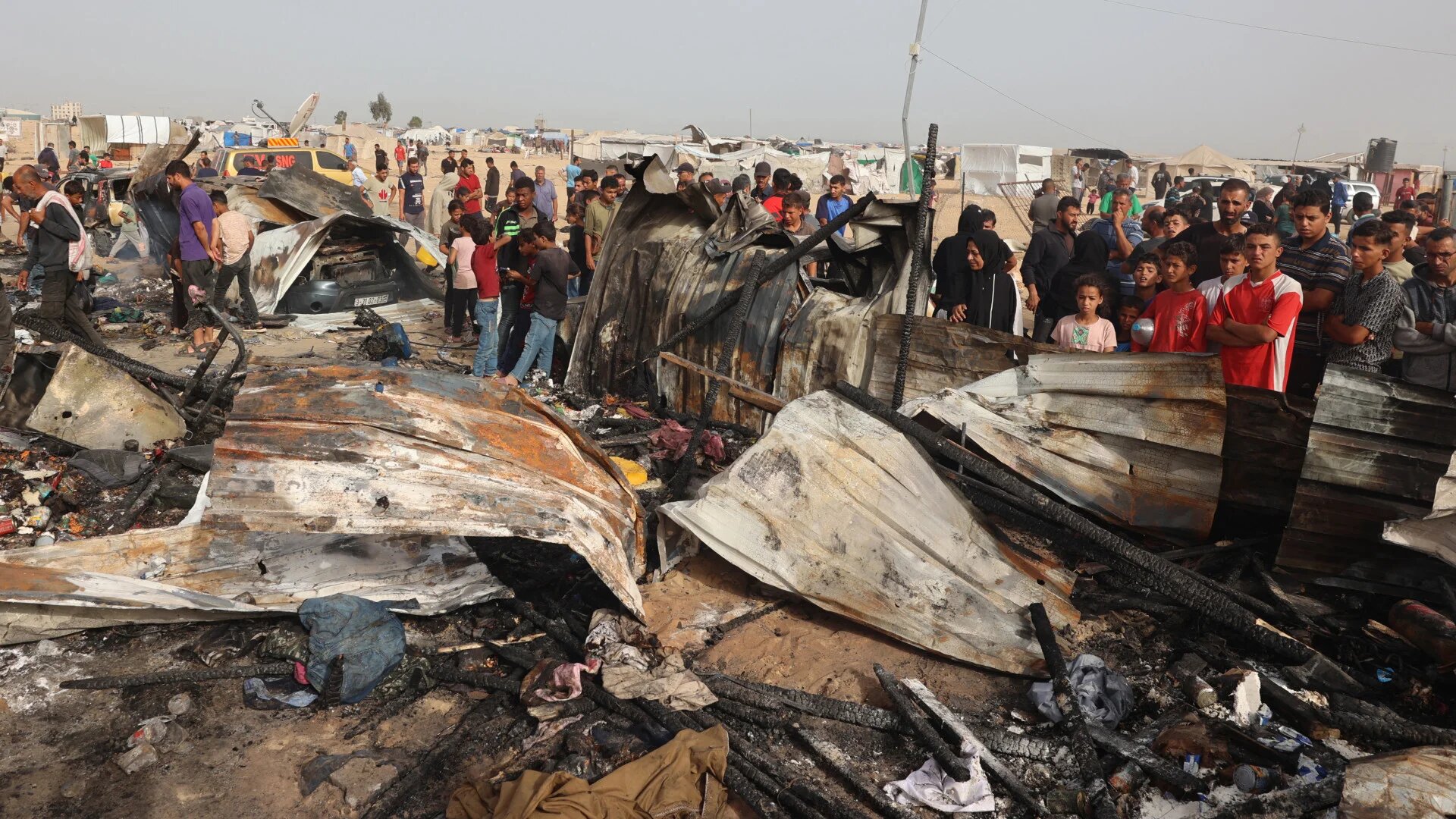 Palestinians gather at the site of an Israeli strike on a camp for internally displaced people in Rafah on 27 May 2024 (Eyad Baba/AFP)