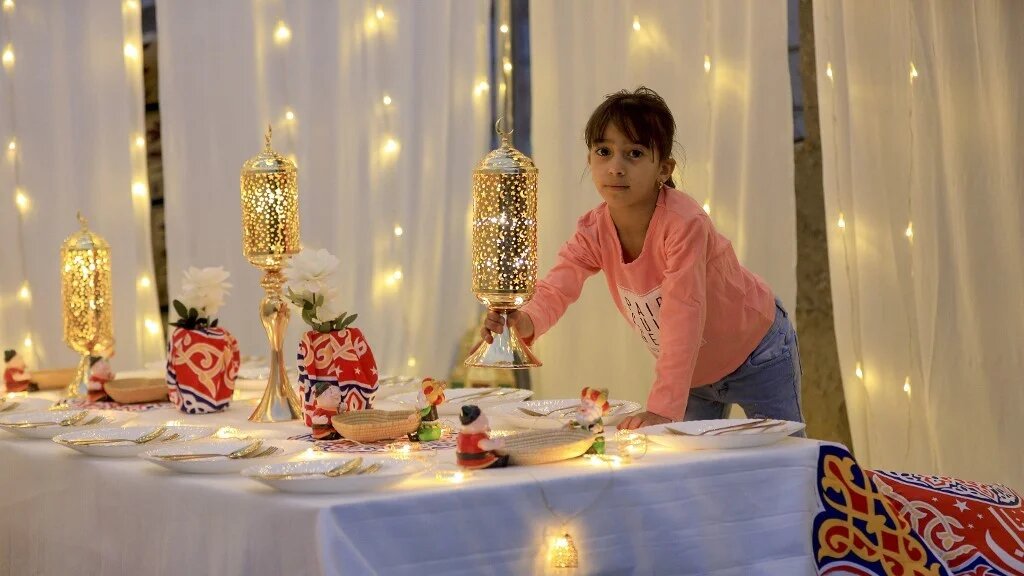 A girl helps prepare a decorated tent on a rooftop, for Iftar meals during the upcoming fasting Muslim month of Ramadan in Sanaa, on March 4, 2023 (AFP)