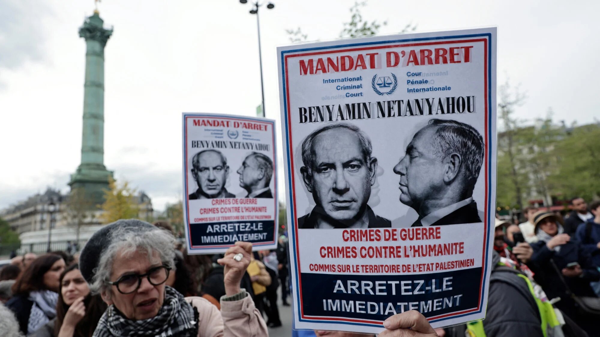 Protesters hold makeshift arrest warrants of Israel's Prime Minister Benjamin Netanyahu during a demonstration in support of Palestinian journalists in front of the Place de la Bastille in Paris, on 16 April 2025 (AFP/Stephane De Sakutin)