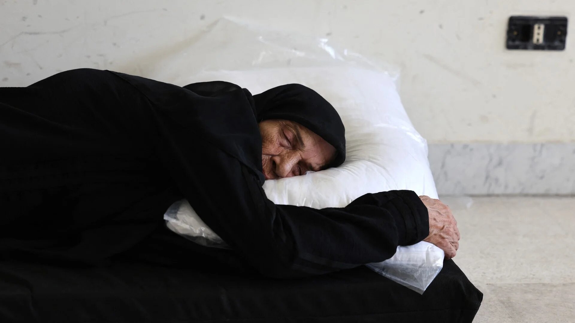 An elderly woman, who fled her village in southern Lebanon, takes refuge at a school turned temporary shelter in Beirut on 24 September (Anwar Amro/AFP)