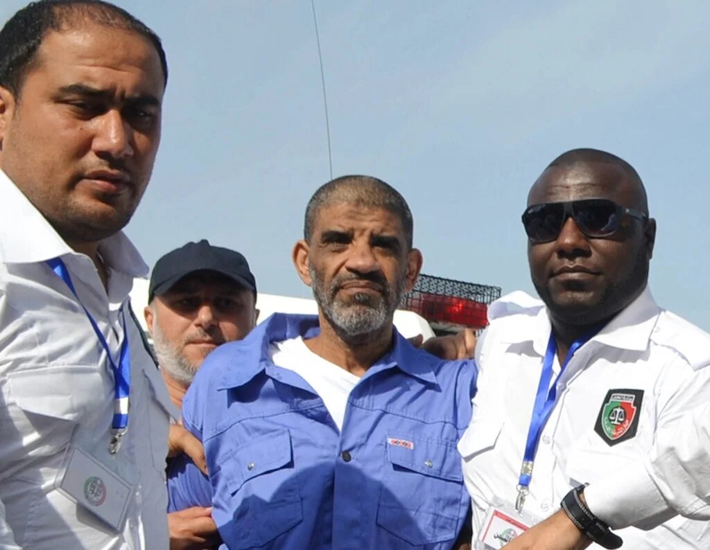 Abdallah Senoussi, ex-chef du renseignement libyen, escorté pour son audience préliminaire à la cour d’appel de Tripoli, le 19 septembre 2013 (AFP)