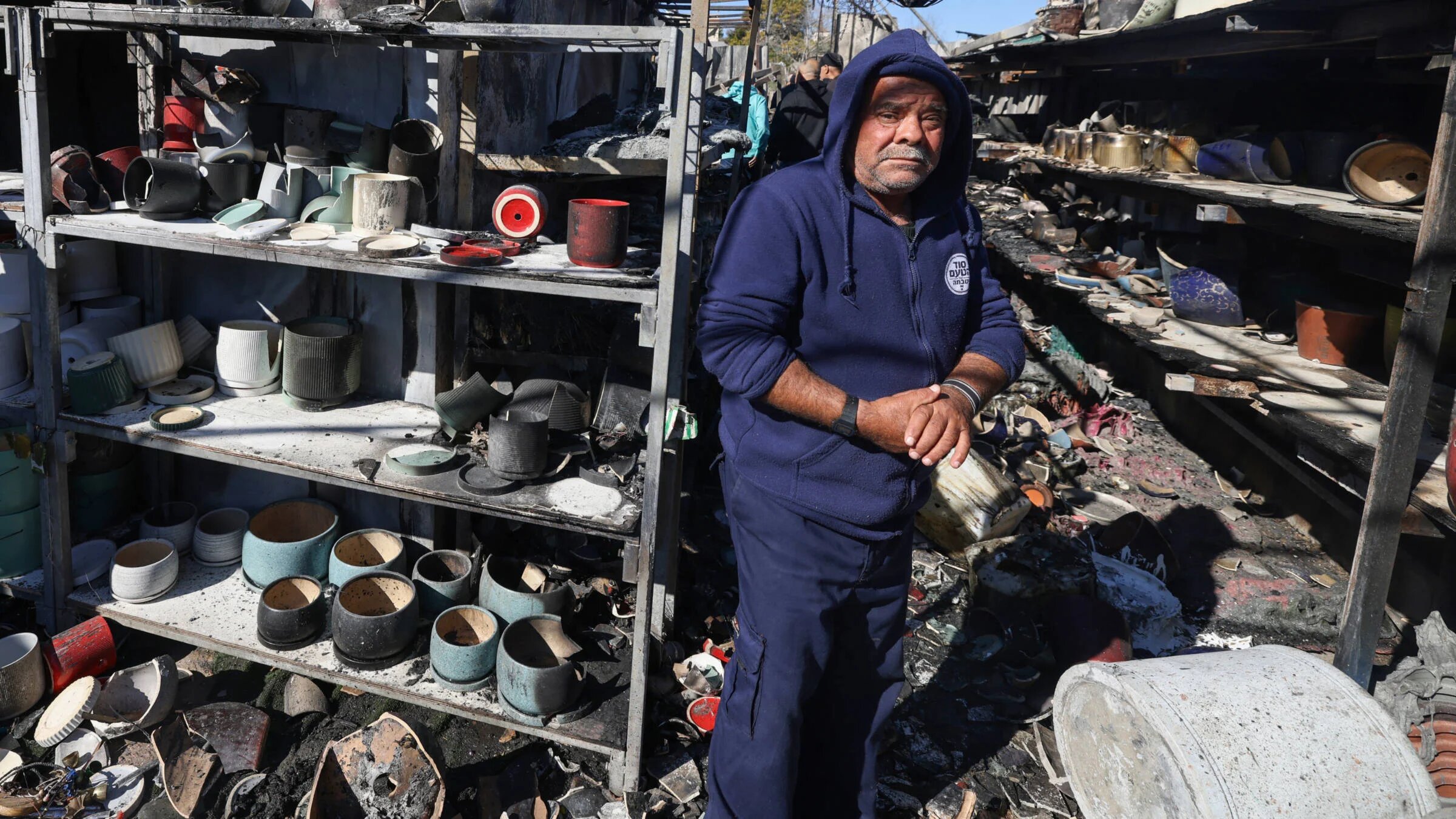 Palestinians inspect the damage at a shop on 21  January 2025 after it was burnt in overnight Israeli settler attacks in Jinsafot village east of Qalqiliya in the Israeli-occupied West Bank (AFP)