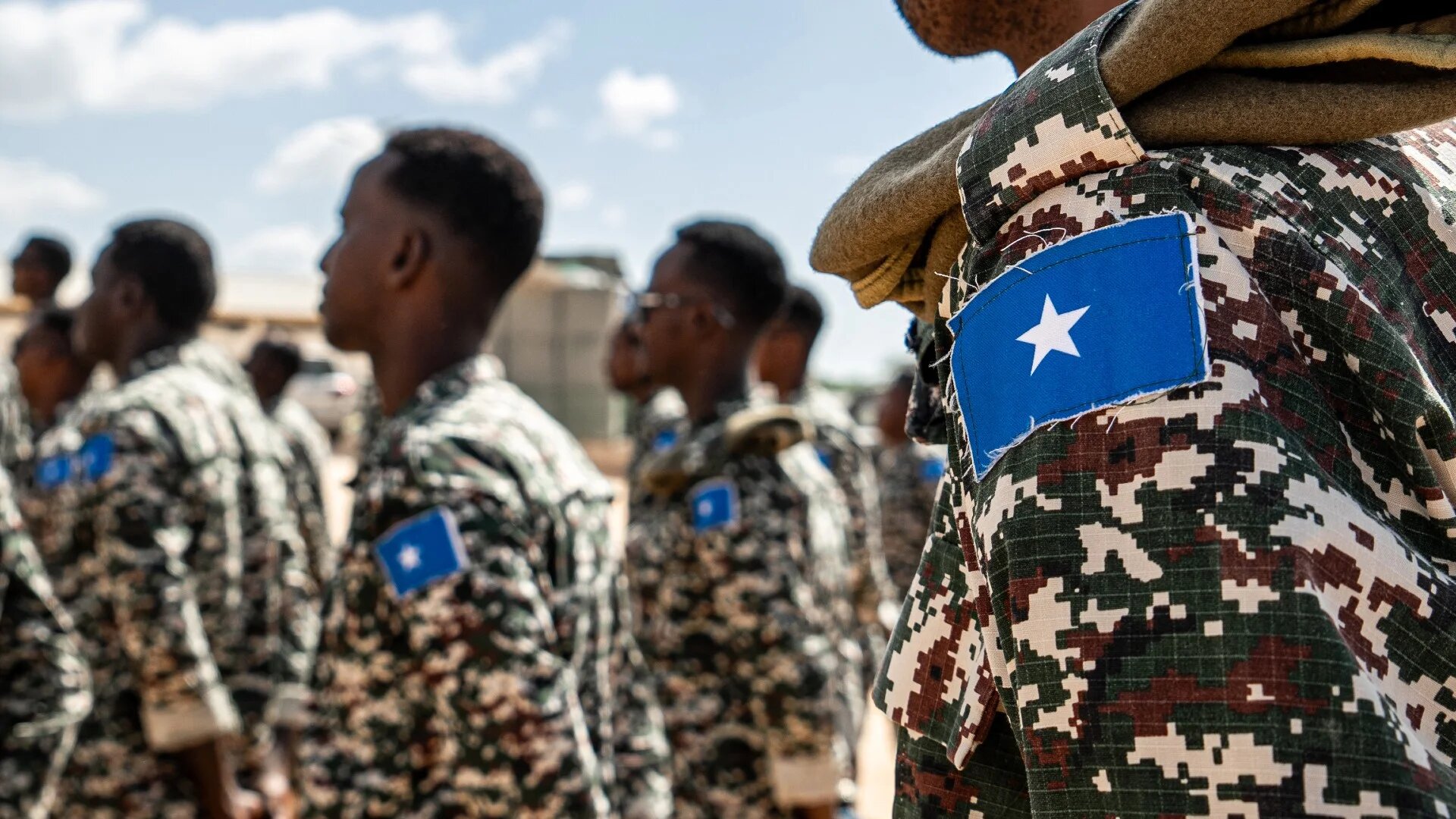 A Somali soldier stands at attention at the General Dhagabadan Training Centre in Mogadishu on 19 March 2024 (Amaury Falt-Brown/AFP)