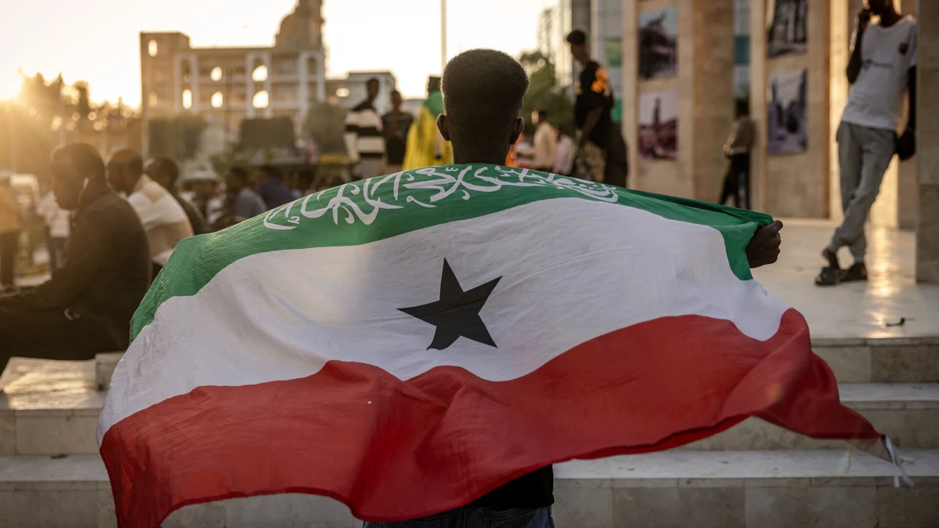 A man holds a flag of Somaliland in front of the Hargeisa War Memorial monument in Hargeisa on 7 November 2024 (Luis Tato/AFP)