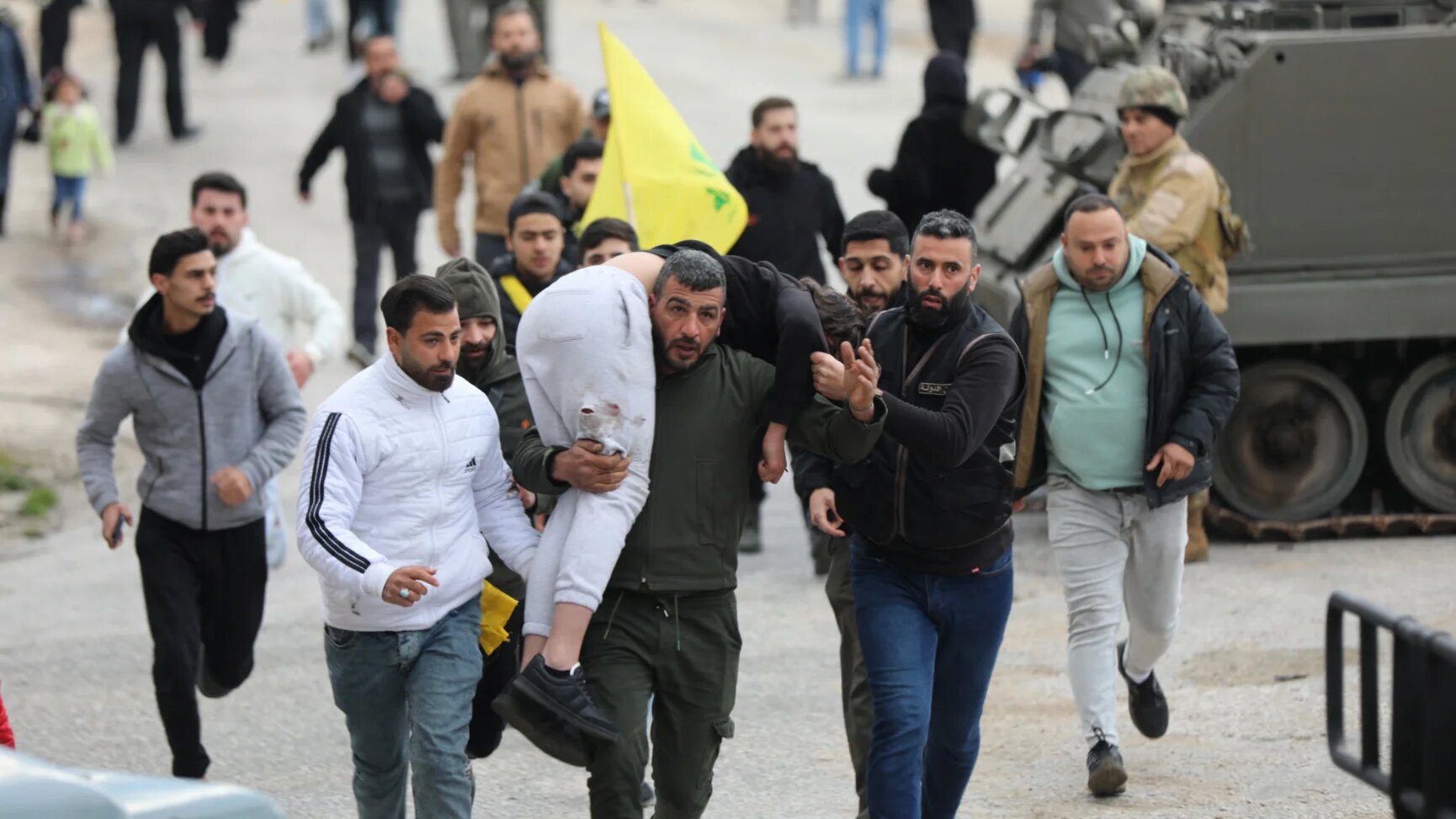 A man carries an injured person in Burj al-Muluk, near the southern Lebanese village of Kfar Kila, where Israeli forces remained stationed on 26 January 2025 (Karamallah Daher/Reuters)