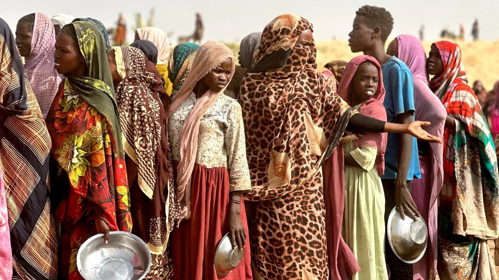 People who fled the Zamzam camp queue for food rations near the town of Taweela in Darfur on 13 April (AFP)