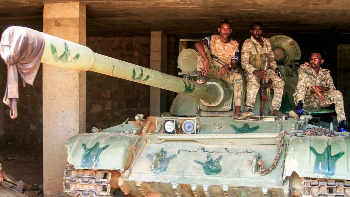 Sudanese army soldiers sit atop a parked tank after their capture of a base used by RSF forces in  Omdurman on 26 May 2025 (AFP)