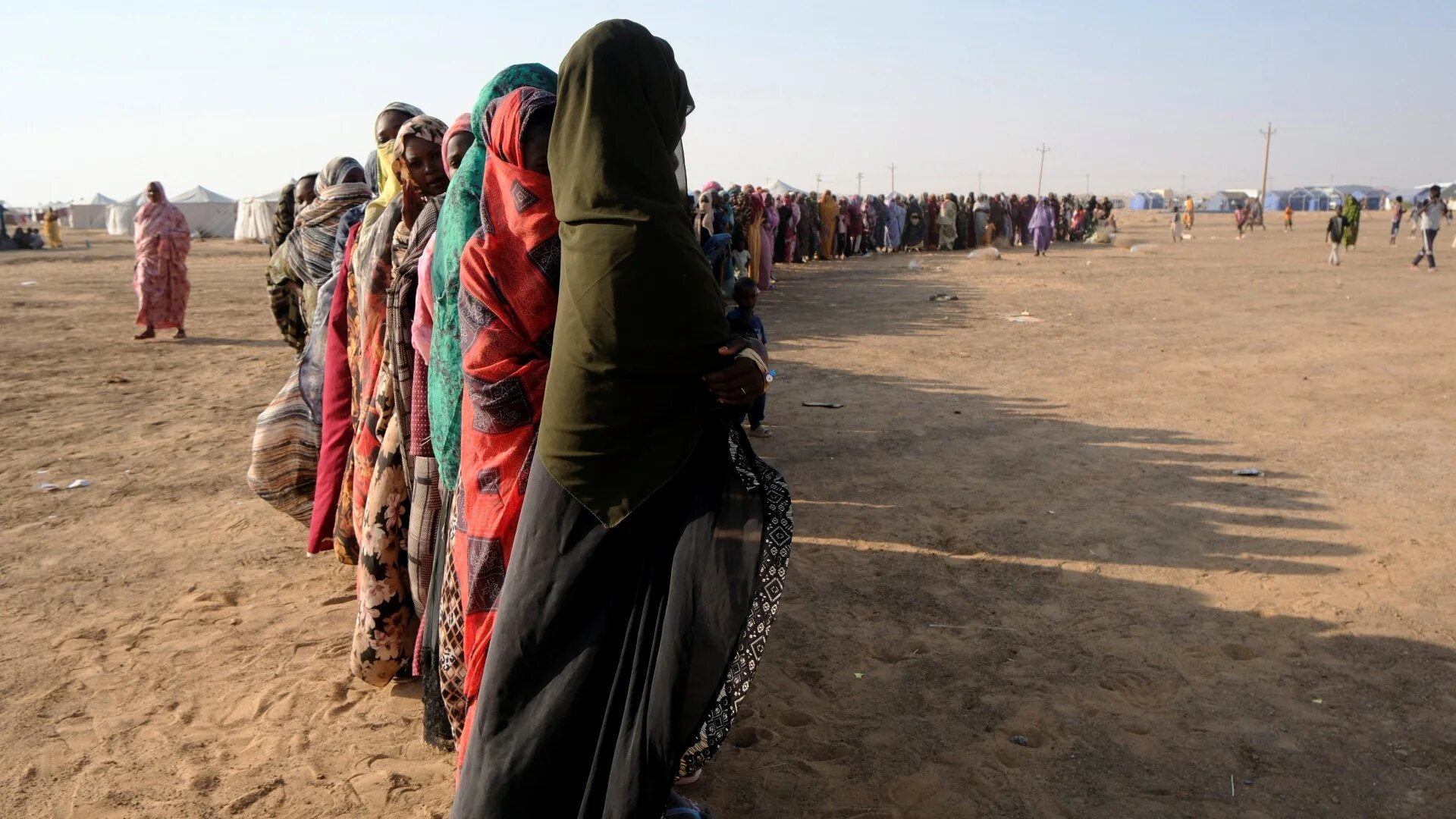 Displaced women stand in a long queue to receive food supplies at a displacement camp in Al-Dabbah, Sudan on 13 November 2025 (Reuters/El Tayeb Siddig)