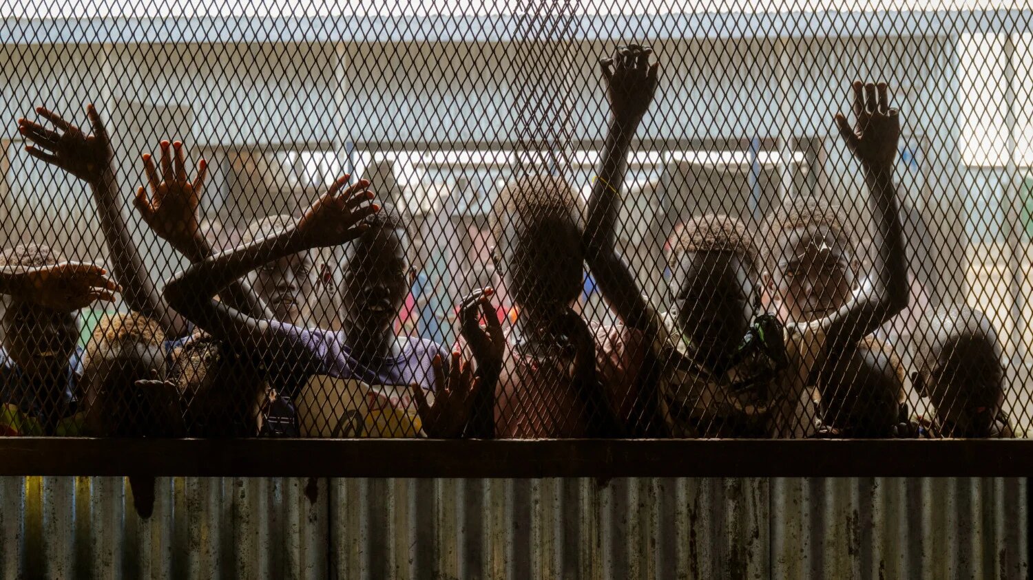 Children gather at the fenced window of a safe-space classroom managed by War Child Holland at the Renk Transit Centre in Renk, South Sudan, on 17 November 2025 (AFP)