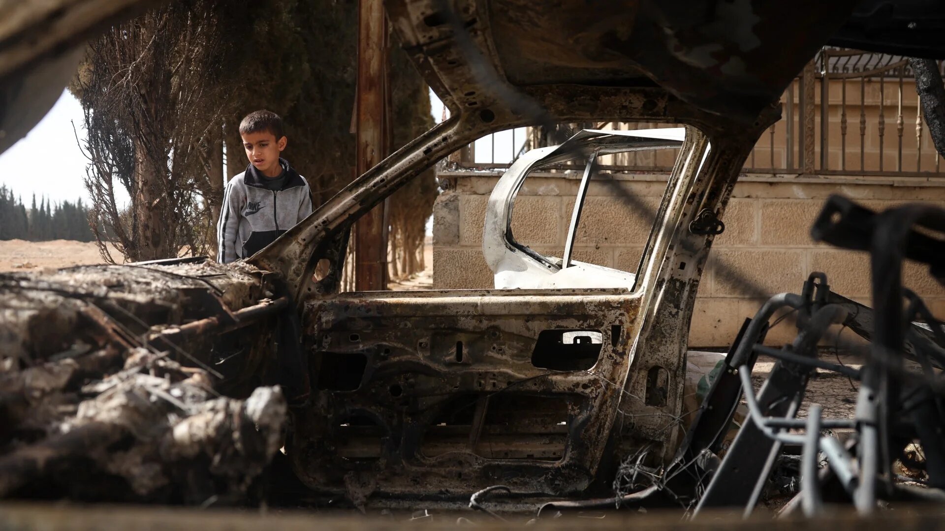 A boy checks a destroyed car following sectarian clashes in Ashrafiyat Sahnaya near Damascus on 1 May (Omar Haj Kadour/AFP)