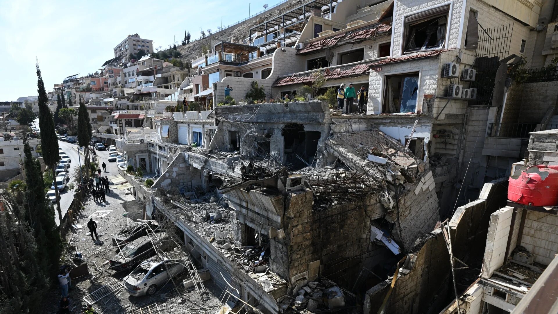 Syrian security forces inspect the site of an Israeli air strike on a building in Damascus on 13 March 2025 (AFP/Louai Beshara)