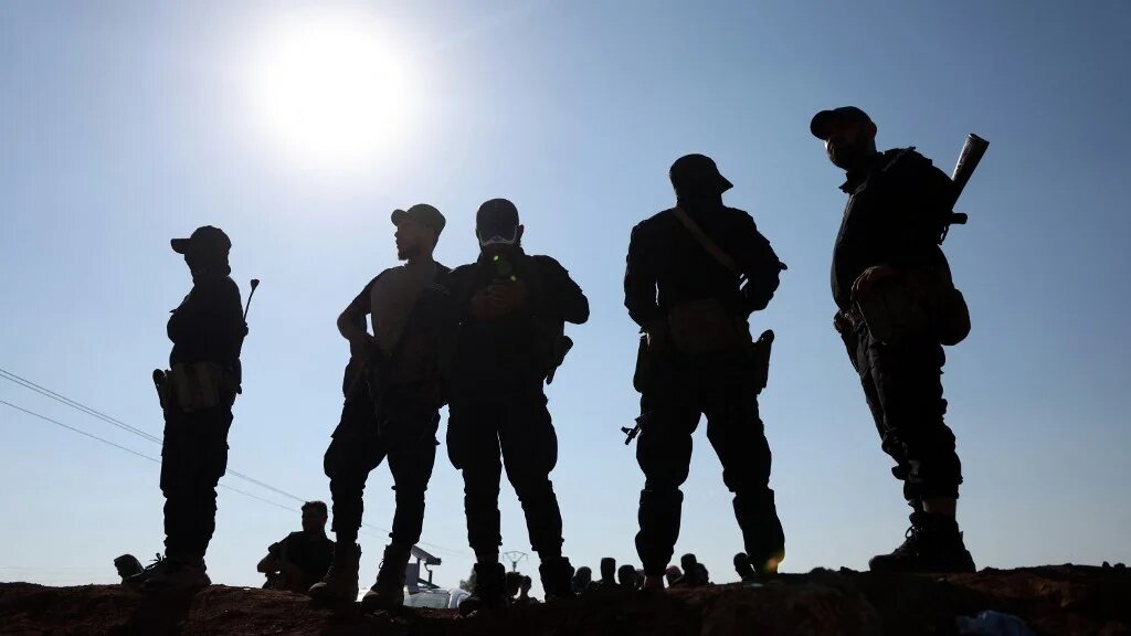 Syrian government forces stand atop an earth barrier in Syria’s southern Daraa province on 21 July 2025 (Omar Haj Kadour/AFP)