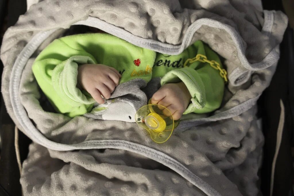 Un bébé dans un berceau dans la « Maison de l’enfant », le principal orphelinat d’Idleb, le 30 avril 2023 (AFP/Omar Hajj Kaddour)