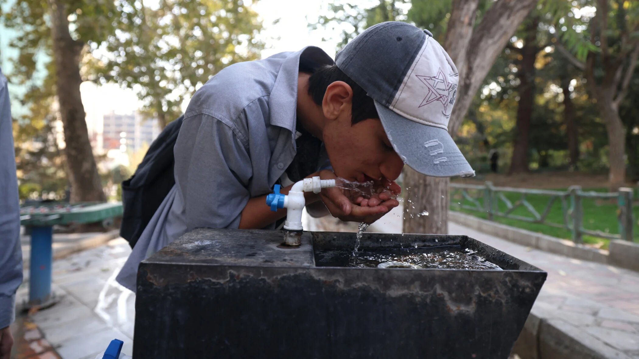 A youth drinks water from a fountain in Mellat Park, Tehran, earlier this month as Iran faces severe water shortages (AFP)