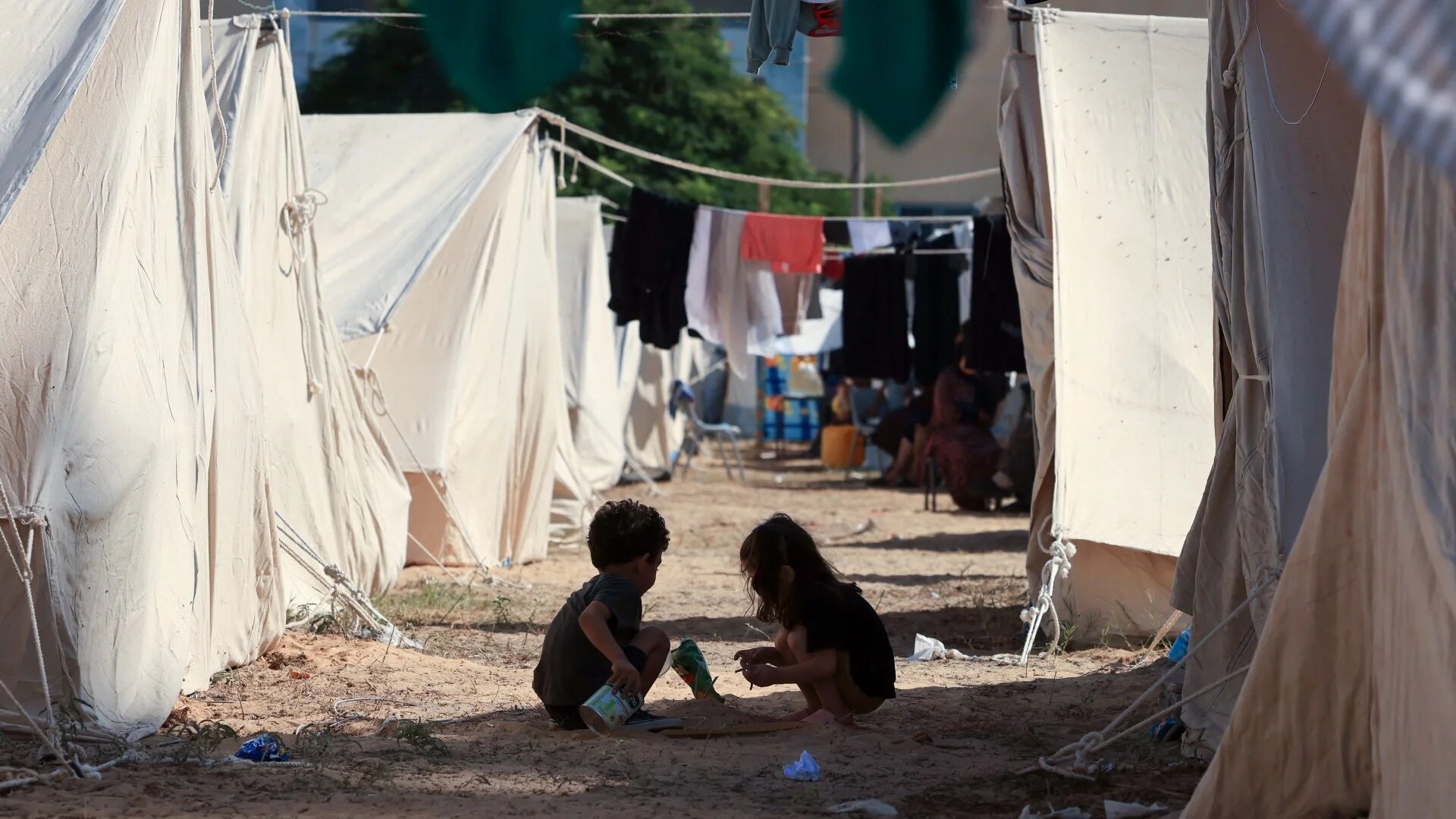 Children play among tents set up for displaced Palestinians by the United Nations Relief and Works Agency for Palestine Refugees (Unrwa) in Khan Yunis in the southern Gaza Strip on 19 October 2023 (AFP)