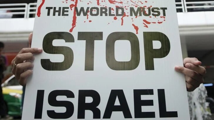 A protester holds a placard outside the Israeli embassy in Bangkok, Thailand, during a demonstration against a previous Israeli war on Gaza in July 2014 (Nicolas Asfouri/AFP)