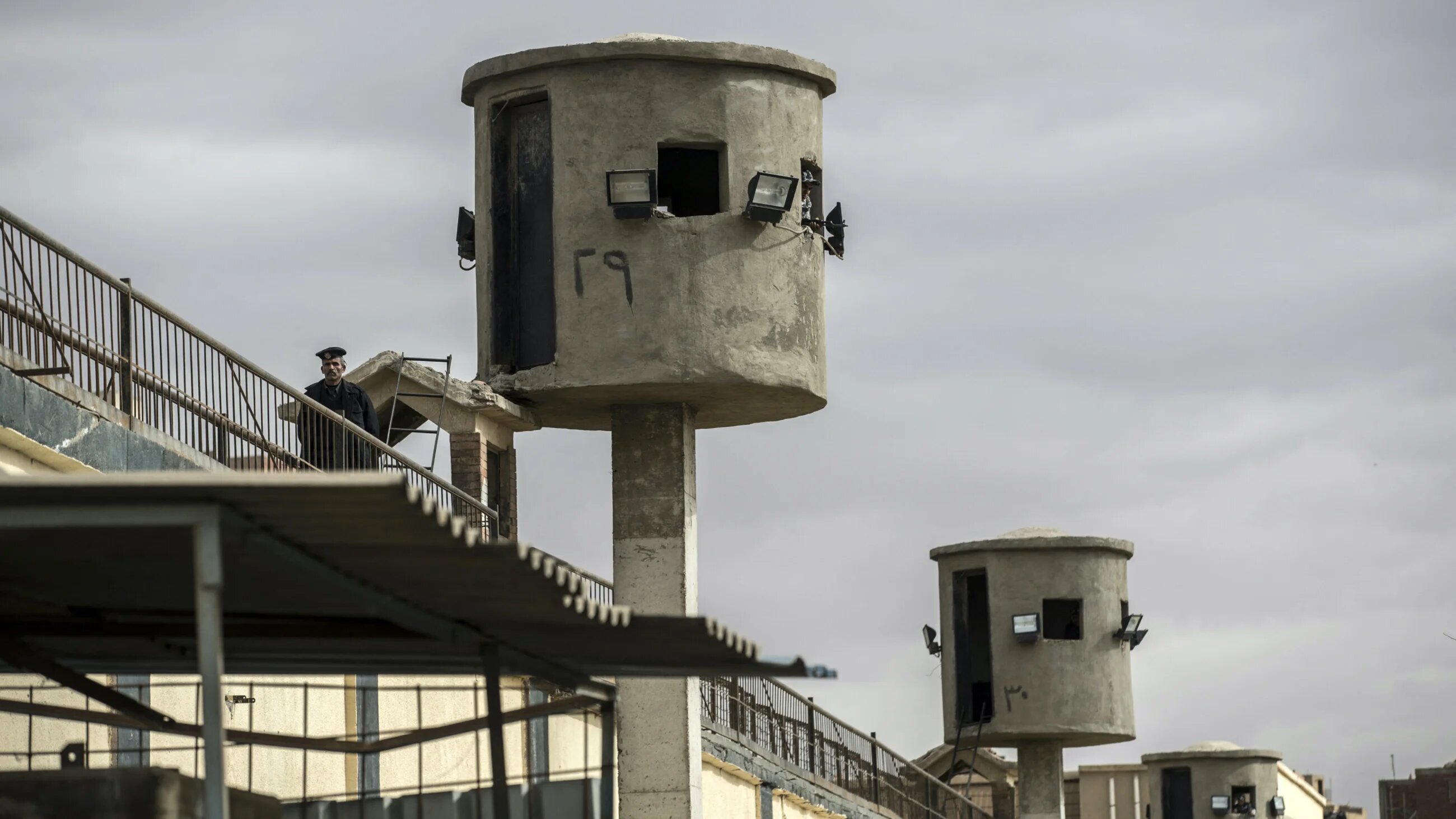 An Egyptian policeman stands near watch towers at Tora prison on the southern outskirts of the Egyptian capital Cairo (AFP)