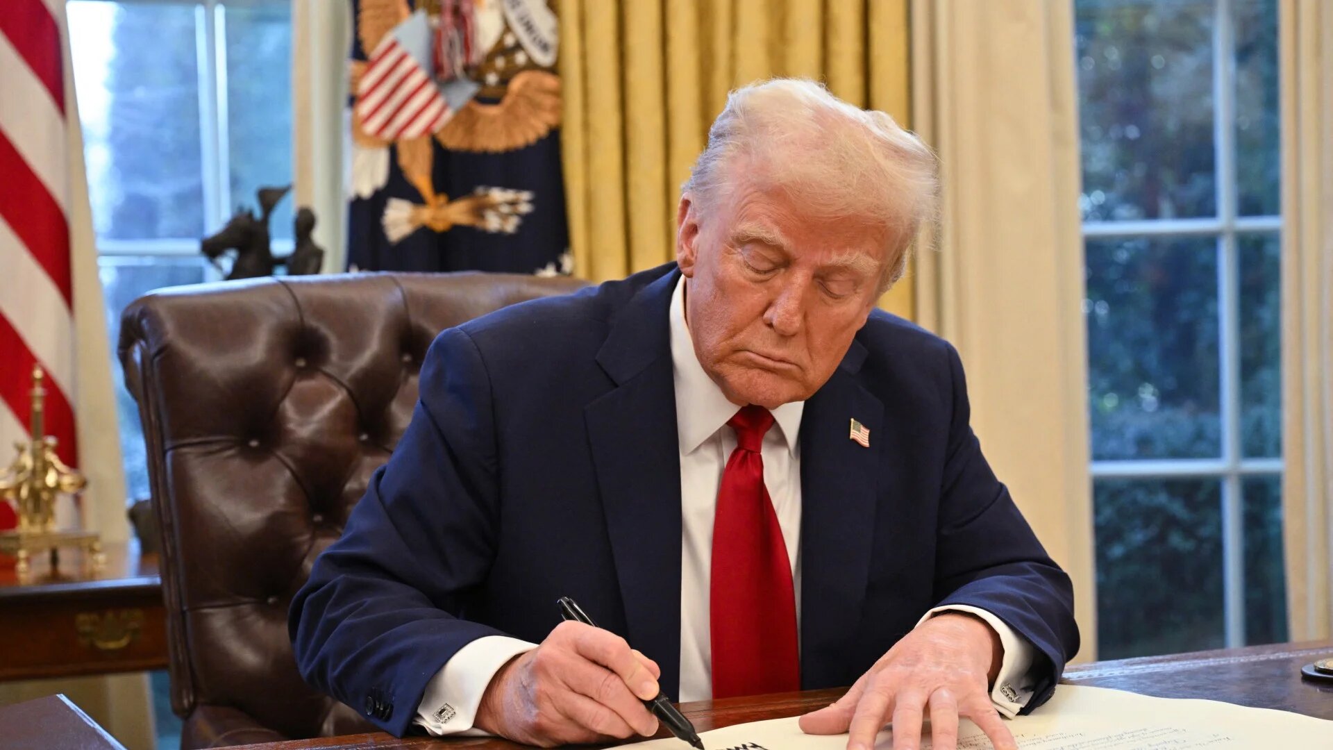 US President Donald Trump signs an executive order in the Oval Office of the White House in Washington, DC, on January 30, 2025.