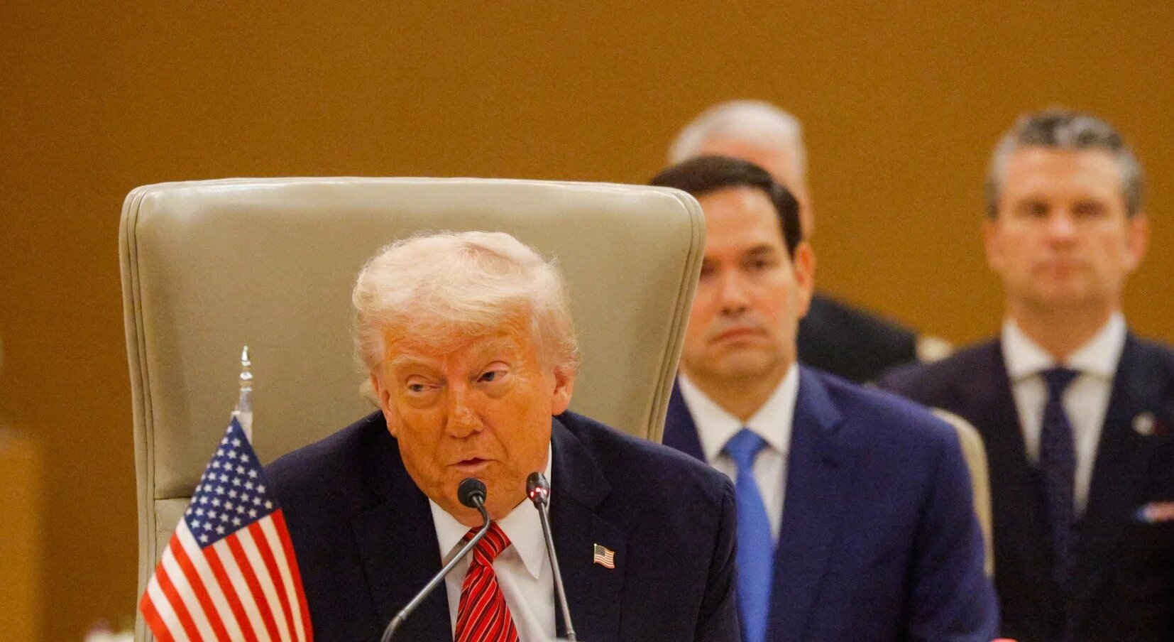 US President Donald Trump speaks at the Gulf Cooperation Council, with US Secretary of State Marco Rubio and Defense Secretary Pete Hegseth seated behind him, in Riyadh, Saudi Arabia, on 14 May 2025 (Reuters)