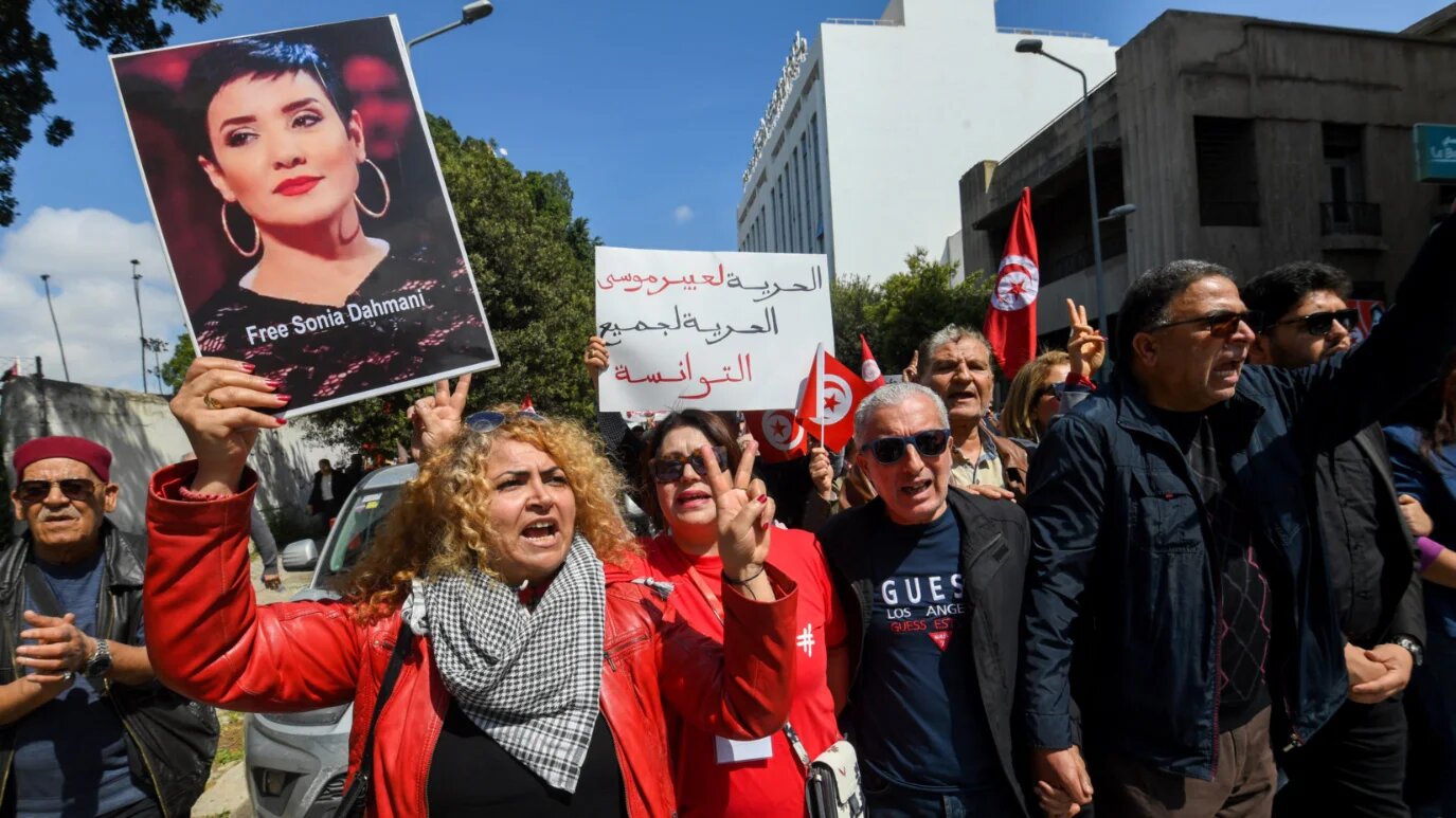 Supporters of Abir Moussi, the head of Free Destourian Party (PDL), and a critic of President Kais Saied, flash the V for victory sign during a protest calling for her release in Tunis on 9 April 2025 (Fethi Belaid/AFP)