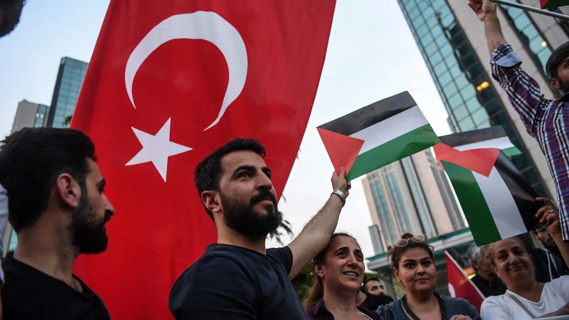People hold Palestinian and Turkish flags as they protest in front of Israel's consulate in Istanbul on 16 May 2018 (Ozan Kose/AFP)