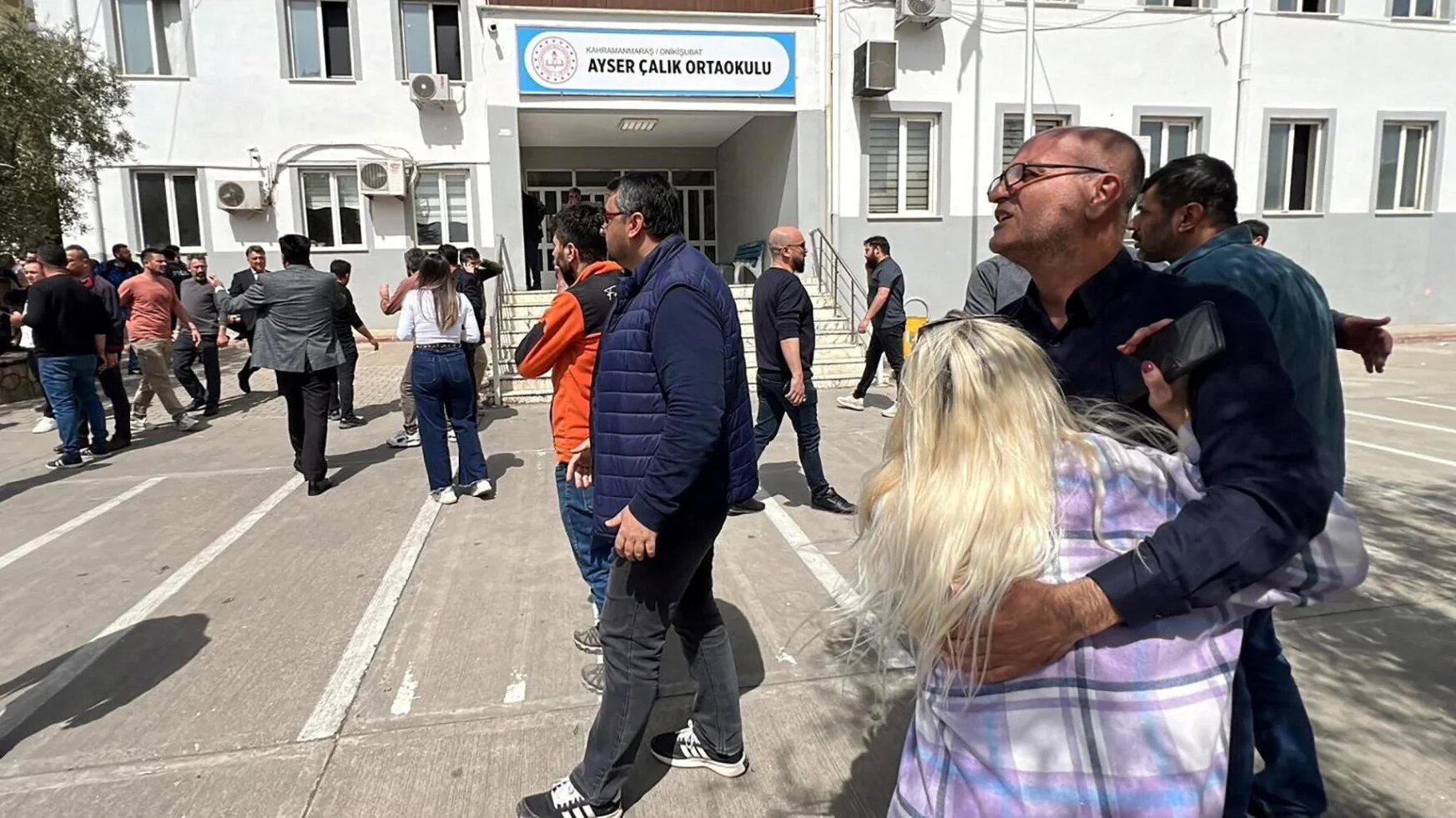 People wait in front of the school building after a deadly shooting, in the southeastern province of Kahramanmaras, Turkey, 15 April 2026 (IHA via Reuters)
